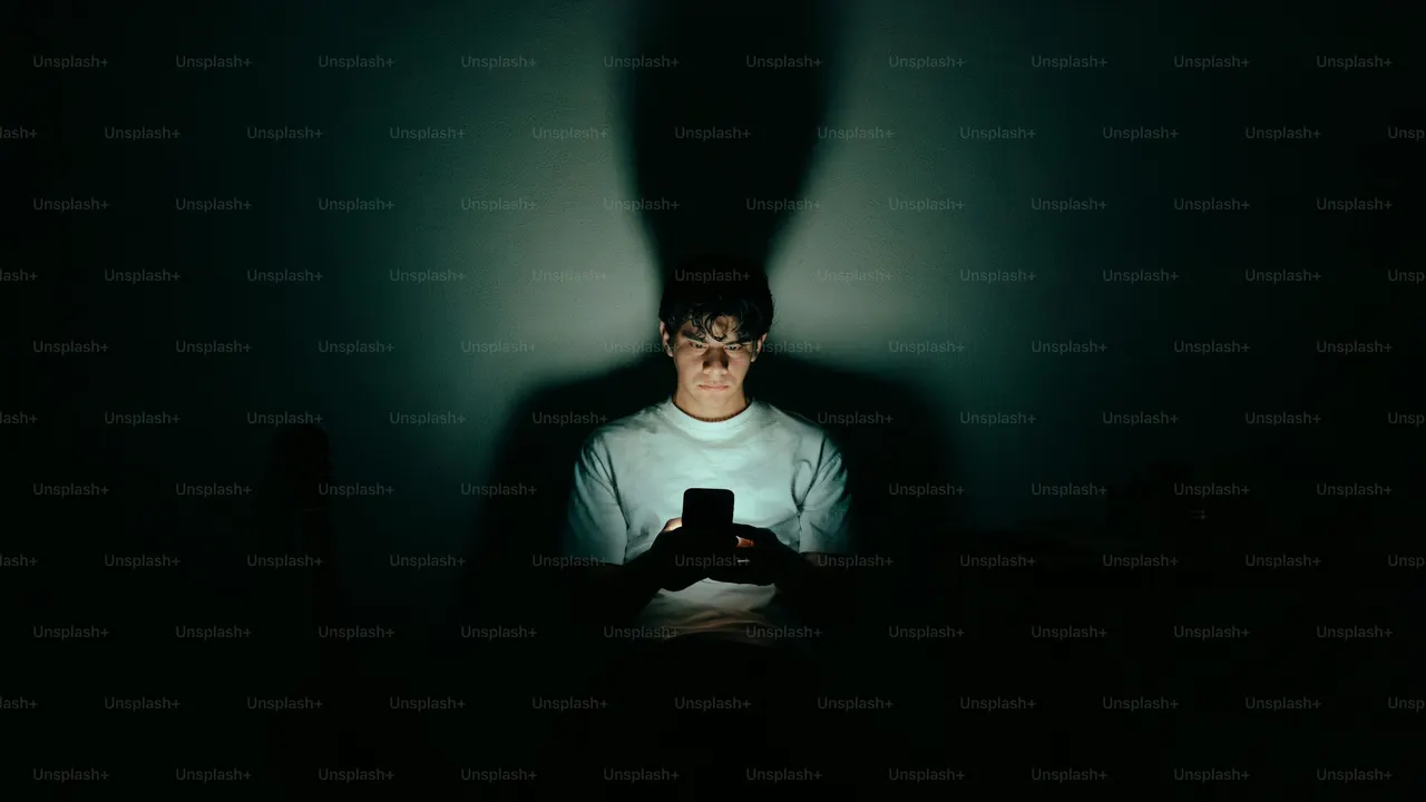 A phone lighting a face in a dark room